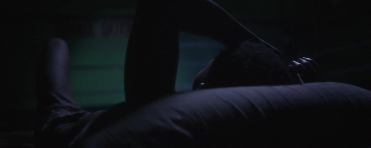 A person lies with their head on a pillow and their left arm resting on their head