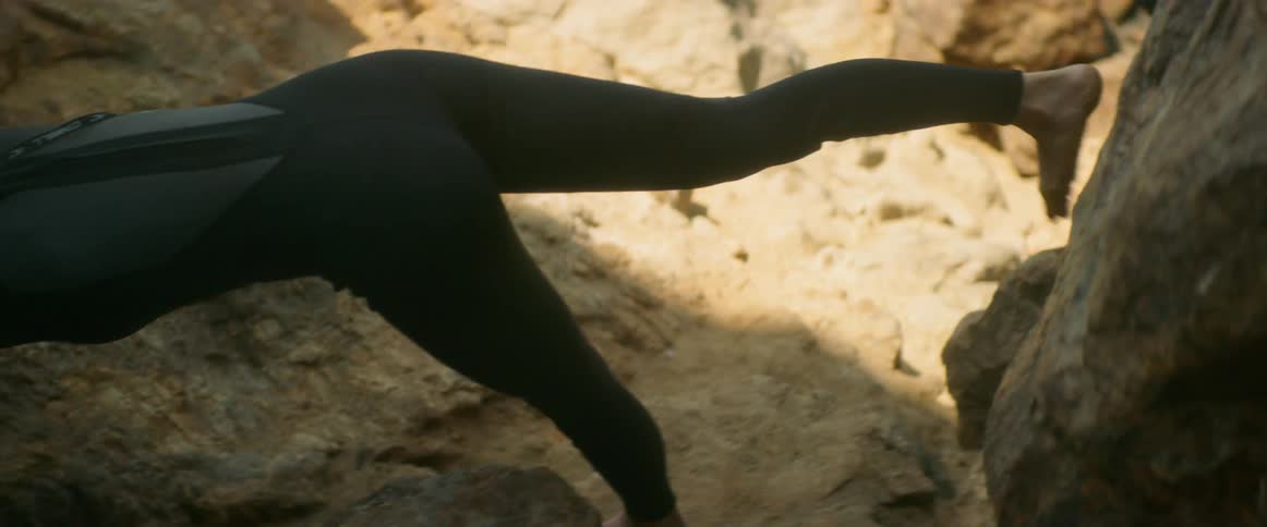 Woman stretching outdoors on rocks
