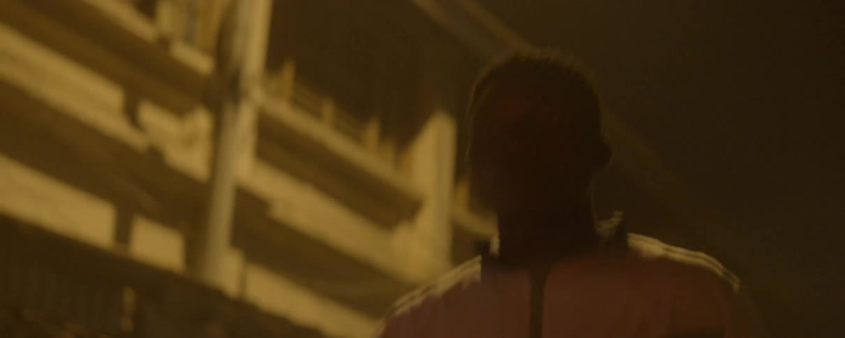 A man runs in a green and white tracksuit