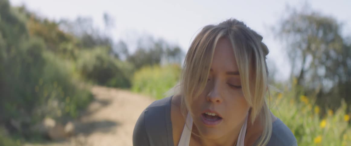 A woman stop running and tries to catch her breath
