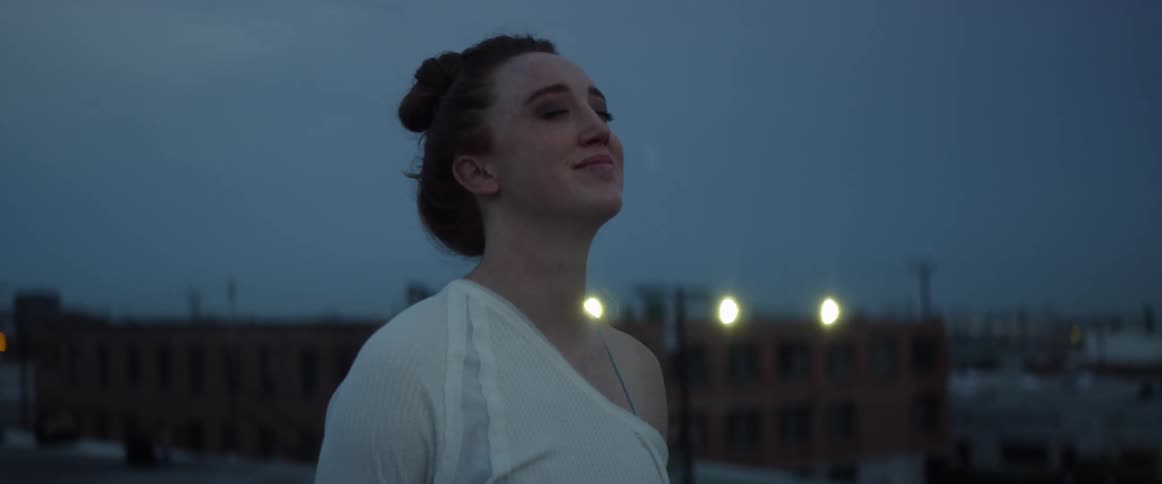 Woman breathes deeply as she stands outdoors