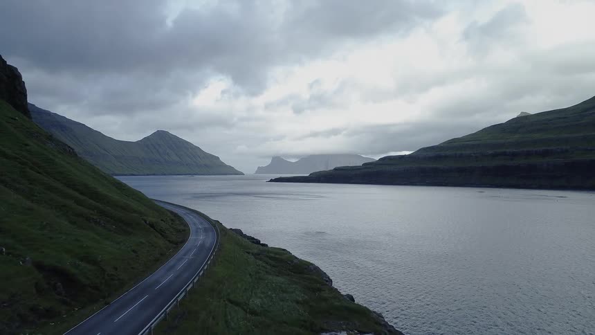 A road on a mountain side next to a large river