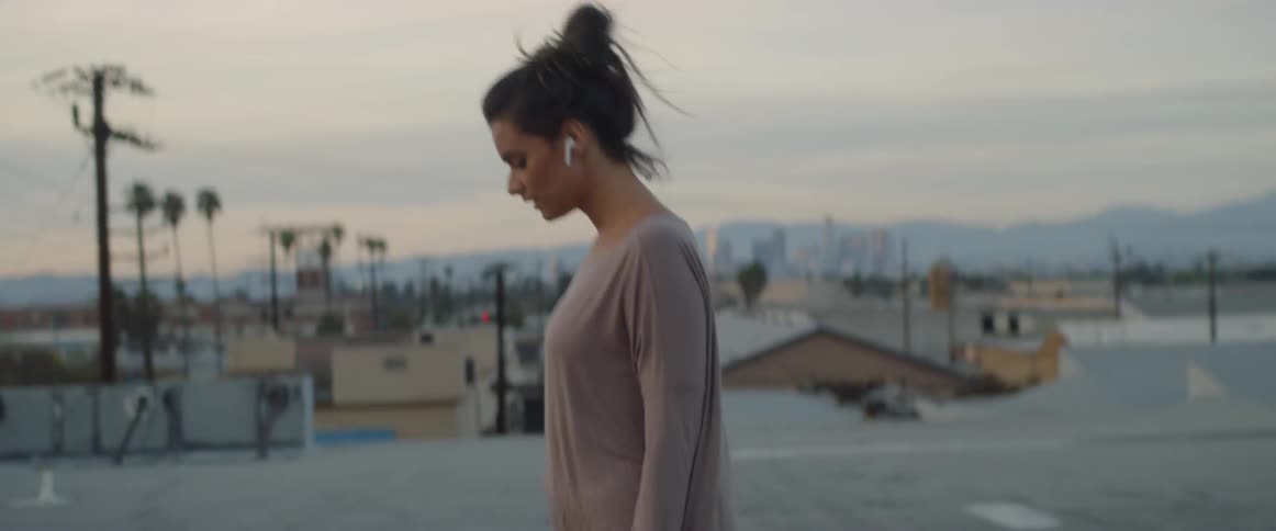 Woman walking on a roof while wearing earphones
