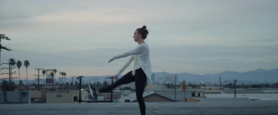 A woman dances on a rooftop