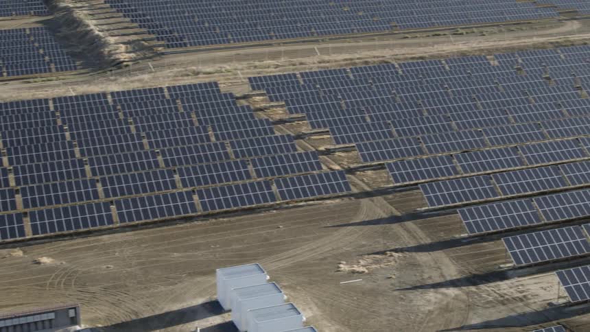 Solar panels are spread out across a desert