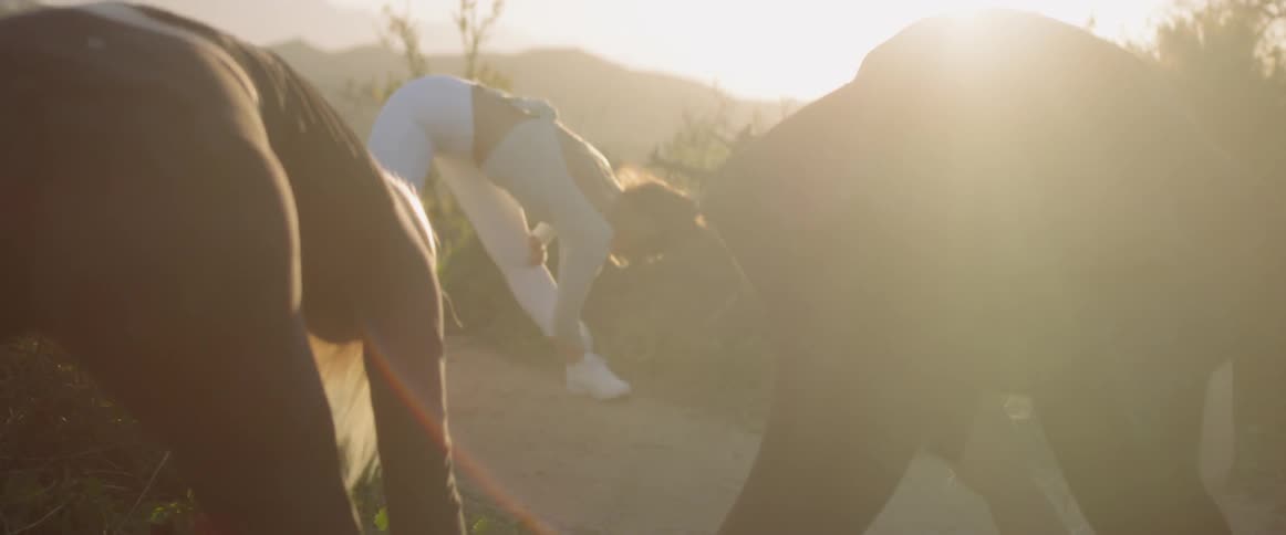 Three women stretch their legs outside