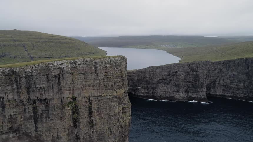 A group of people stand at the edge of the cliff