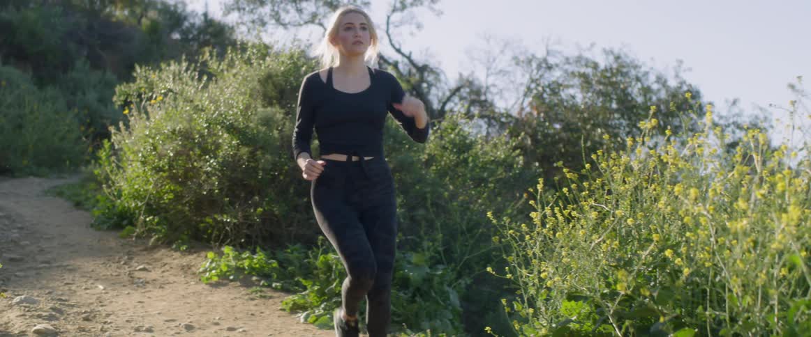 Woman running on a dirt road on a sunny day
