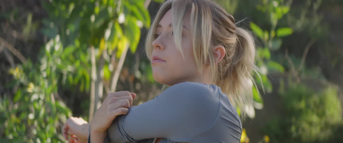 Woman stretching outdoors on a bright day