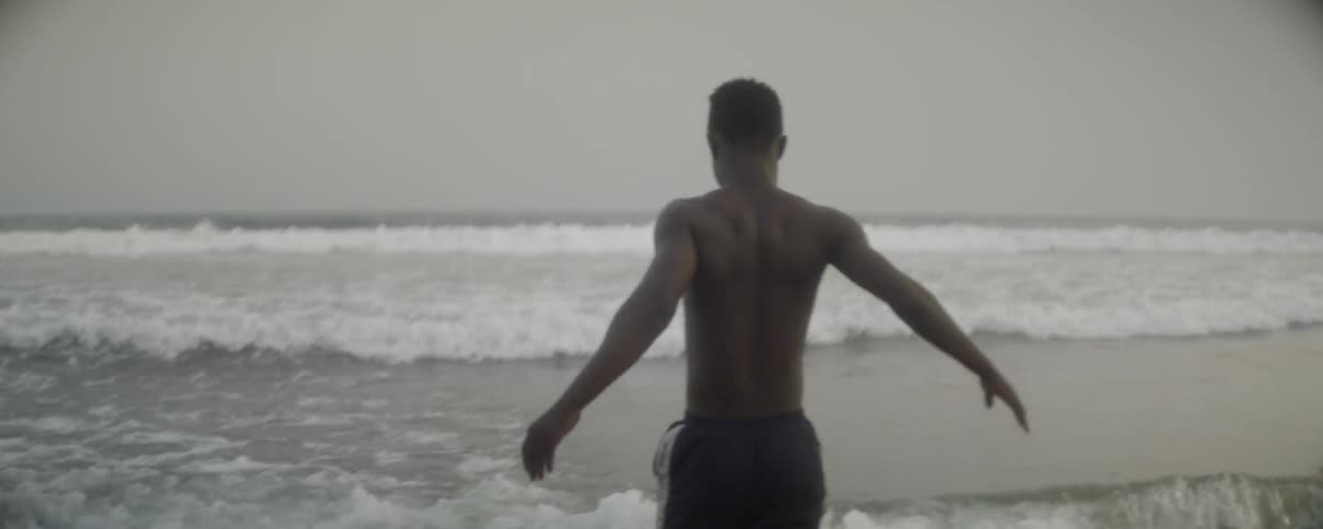 Man walking and stretching in the waves on a beach