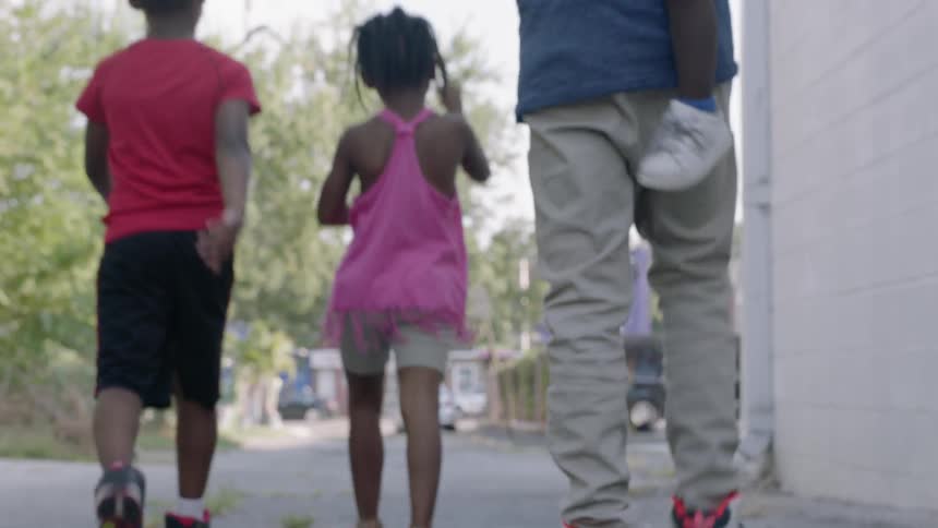 Children walk in an alleyway in a city
