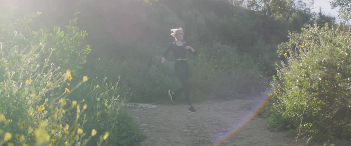 A woman running on a path on a sunny day