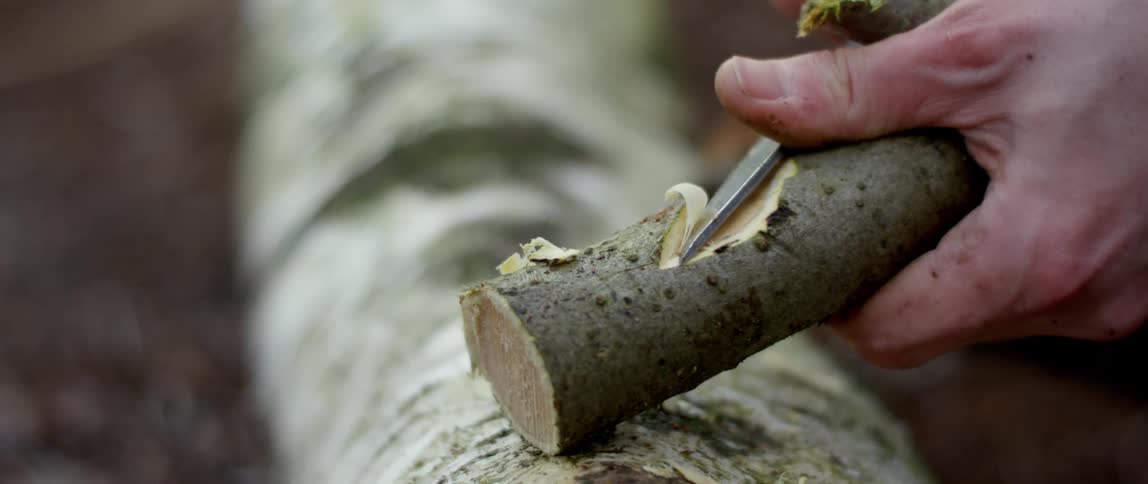 A person is carving a piece of wood