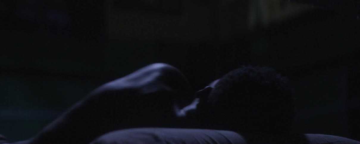 A man rolling around on his bed unable to sleep at night