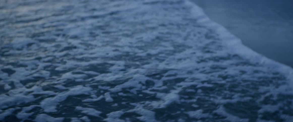 Waves rolling over on a beach at sunrise