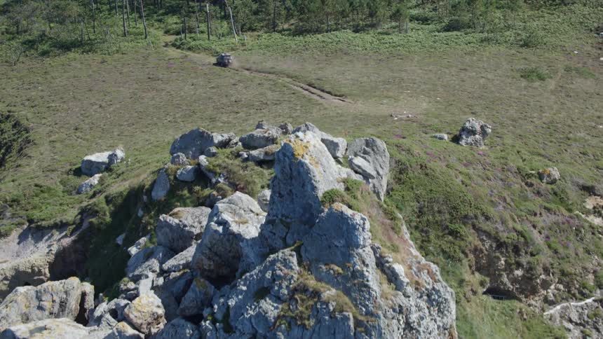 A vehicle driving away from the cliff into the woods
