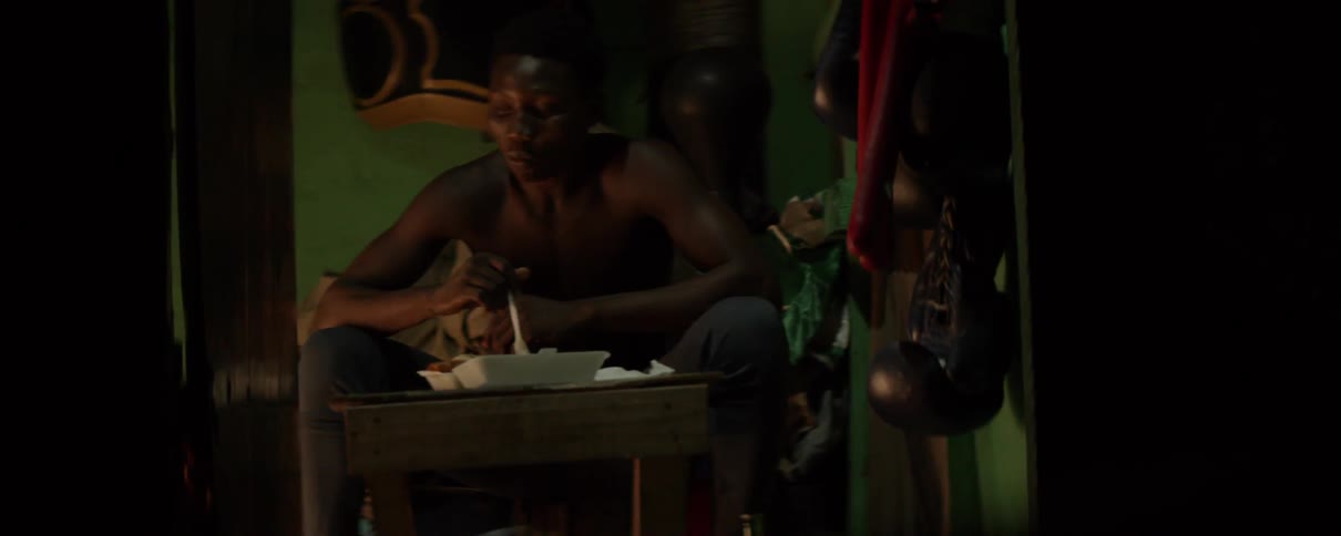A man sits alone as he eats food out of a styrofoam container