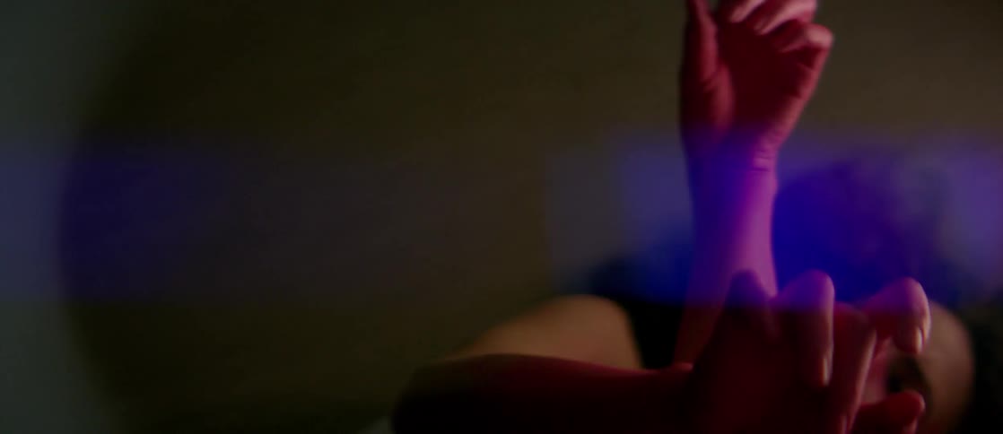 Woman with pink dyed hands moves them slowly through the air