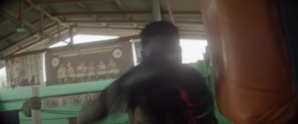 A man aggressively punches a punc\hing bag