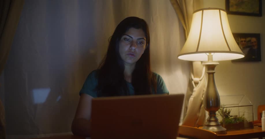 Woman sitting at a table working on her laptop
