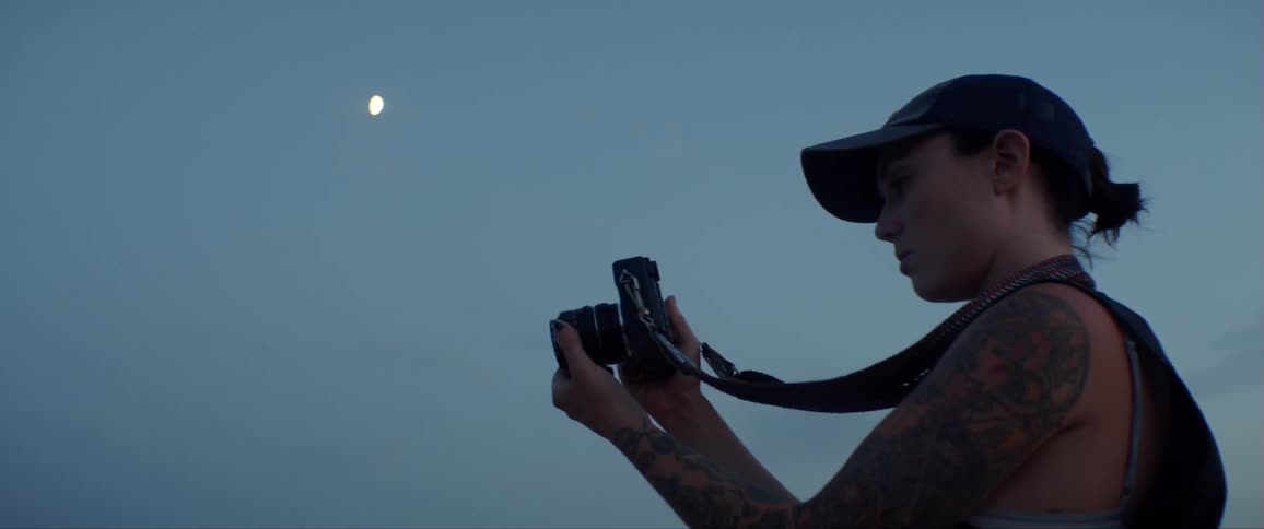 A female photographer looking at the preview screen of her camera