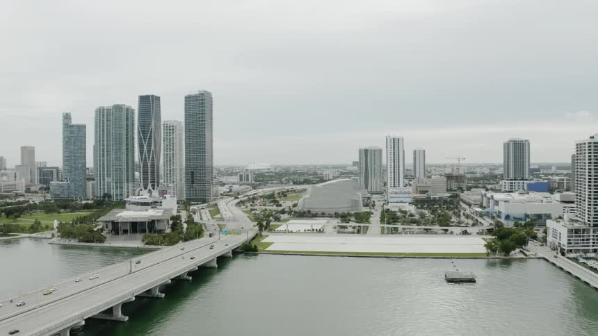 We move along the coast over water beside a huge city until we move over a busy bridge