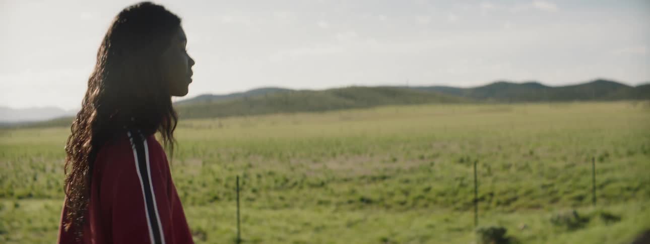 Two woman stand in the remote countryside on a road talking
