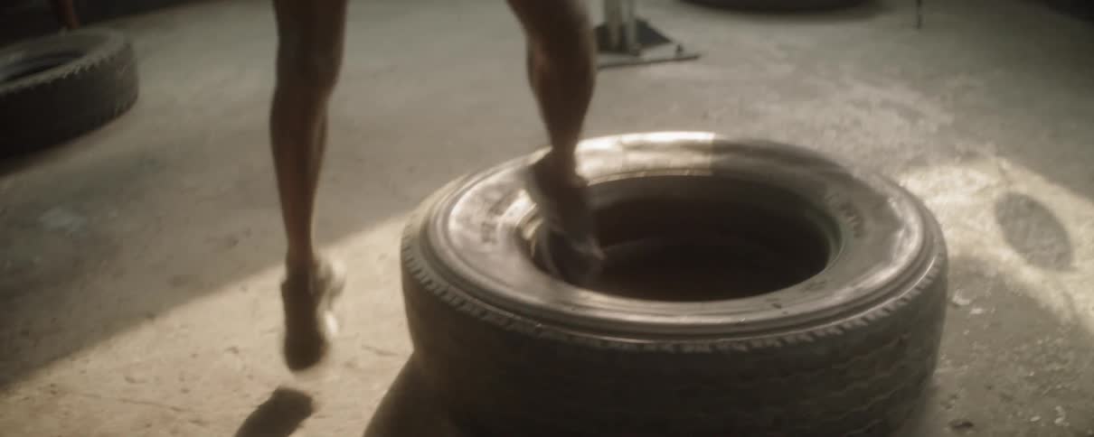 A man exercises with a large tire