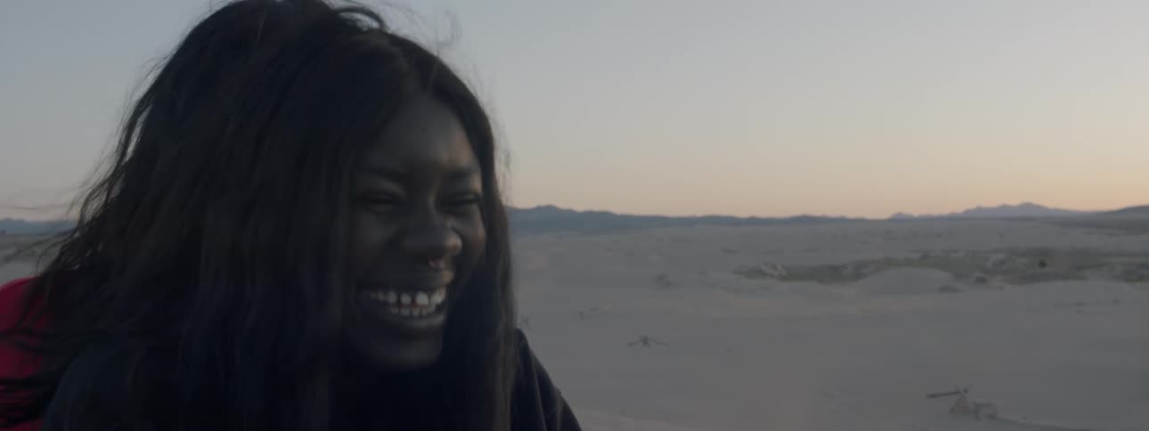 Woman smiling and laughing in the middle of a desert
