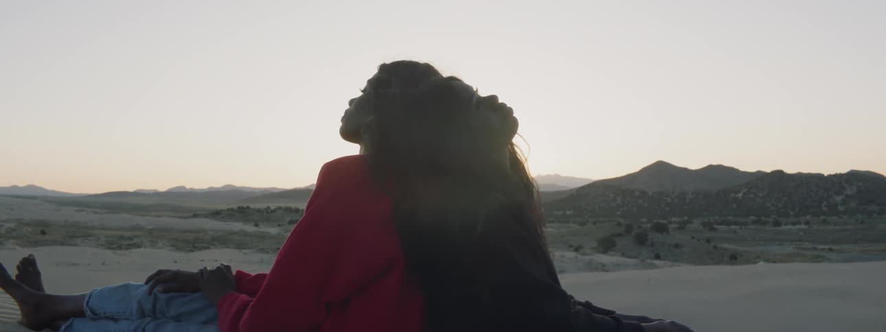 Two women are leaning on each other outside