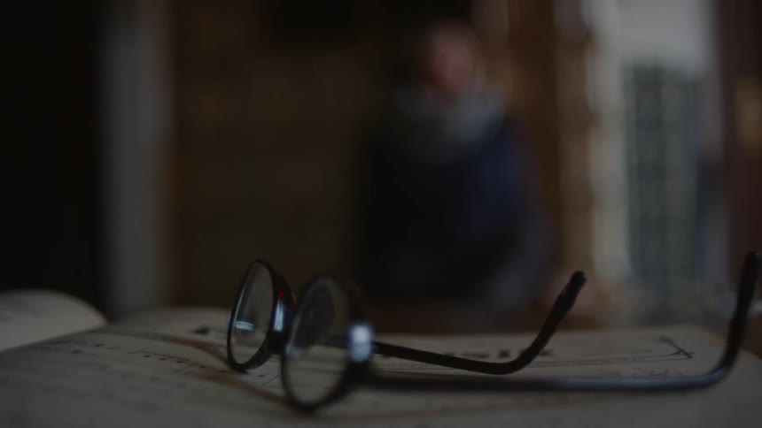 A pair of glasses lays on a book