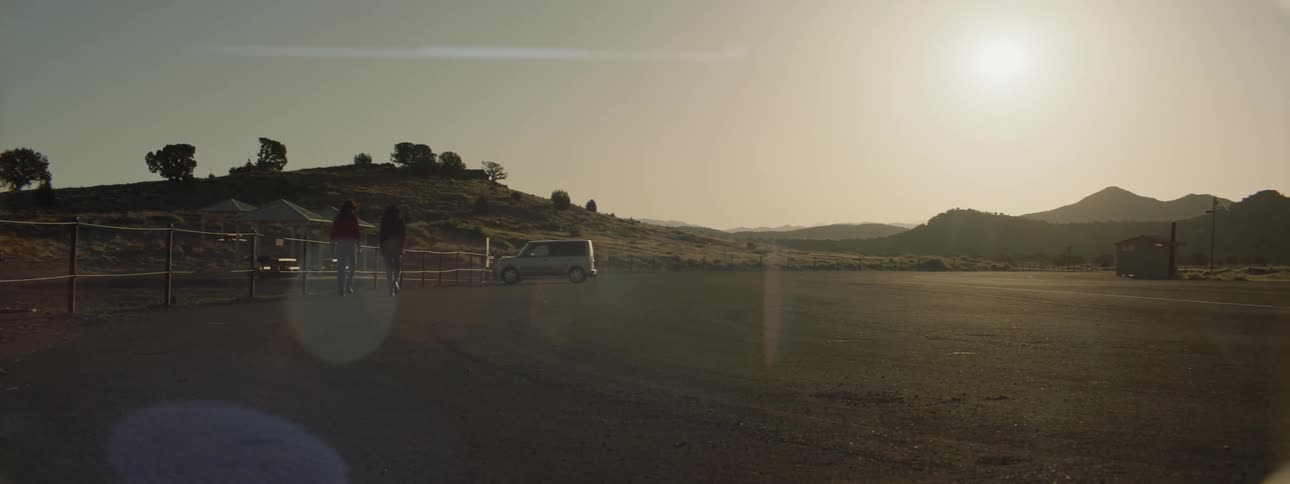 Women walk in a large lot toward a vehicle