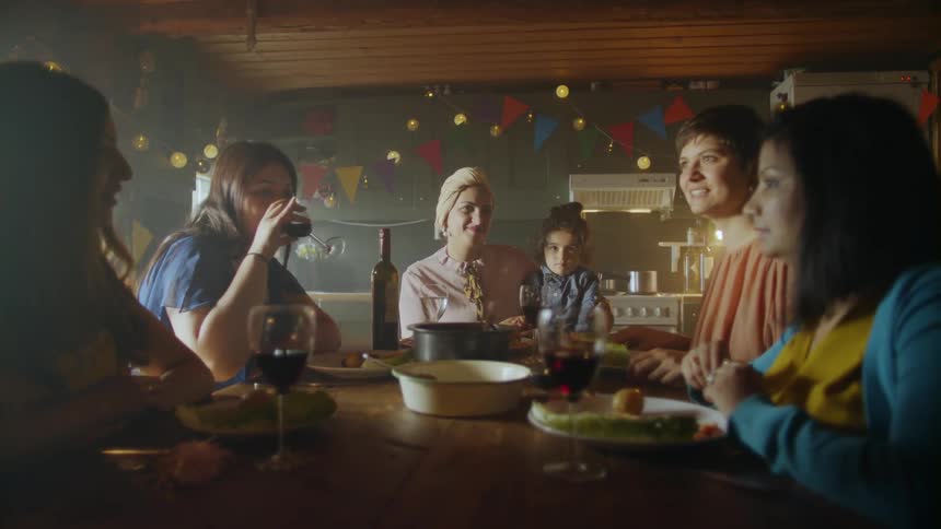 A family sits around a table for a celebration eating and drinking wine