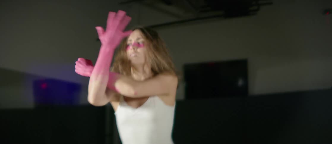A young girl dances with pink paint and a white leotard