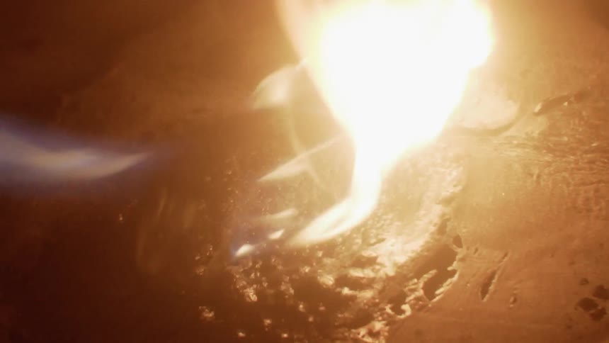 Fire blazes brightly over a bumpy surface