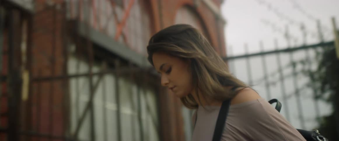 A woman walks up the stairs to a red brick building