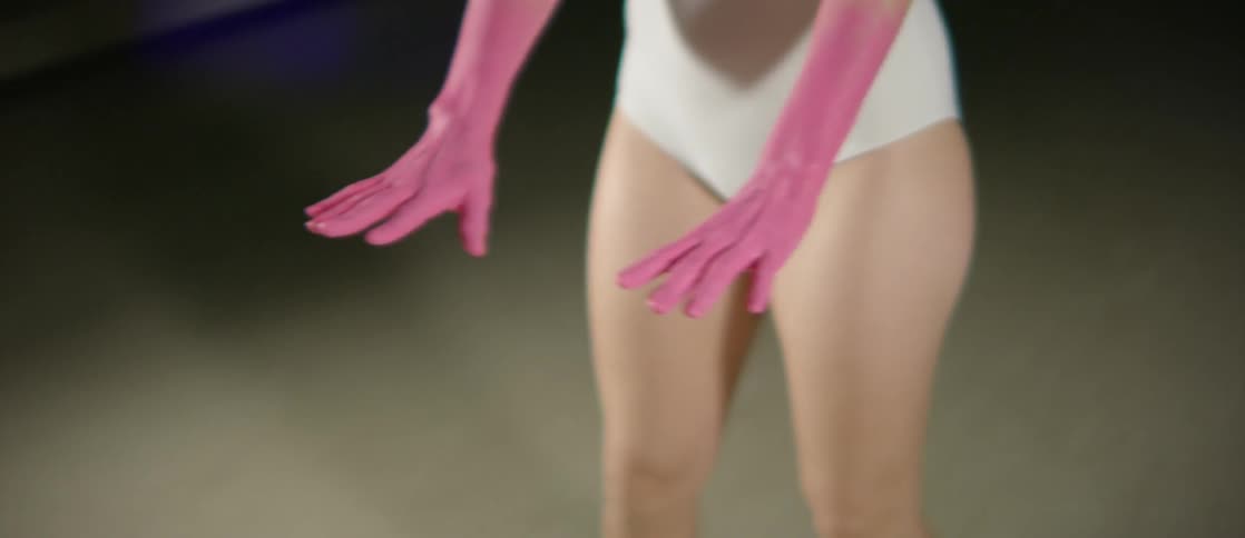 Woman with pink hands holds them out, palms down
