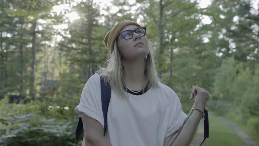 A young woman takes a photograph in nature