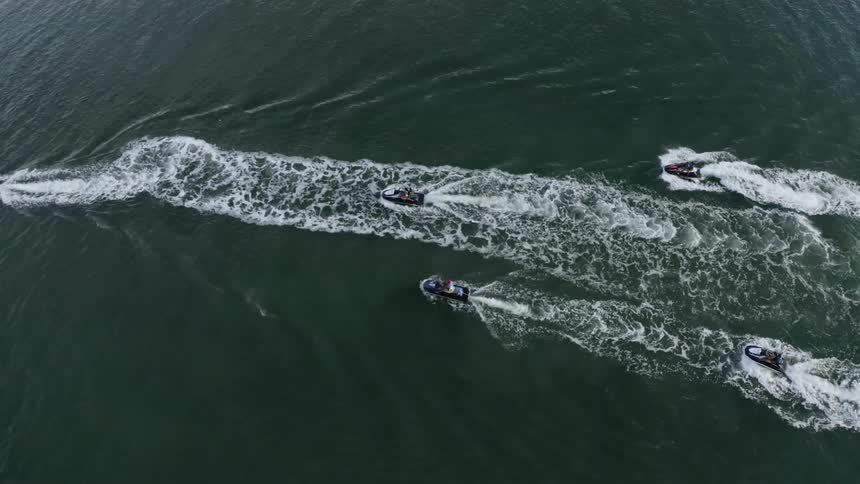 Three boats sailing on the water making large wakes