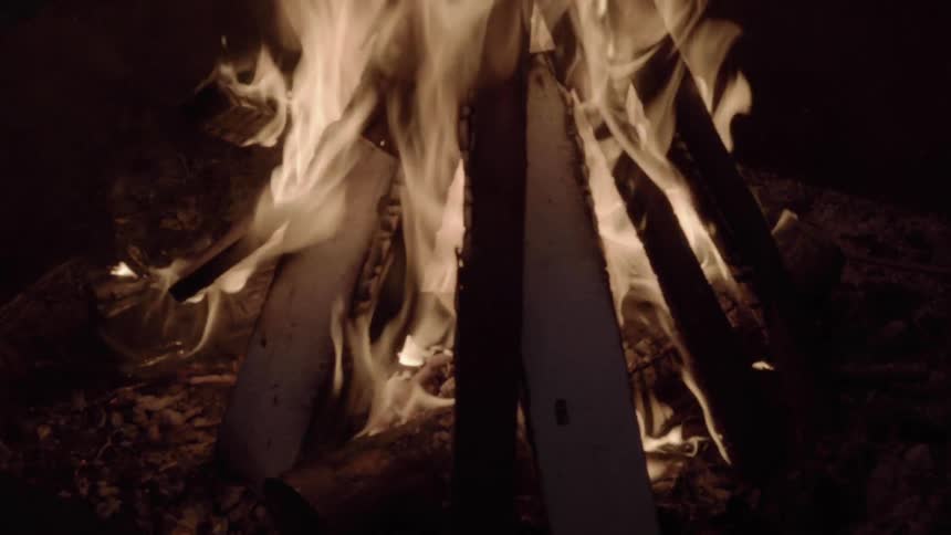 Sticks in a tipi formation burn brightly in the night