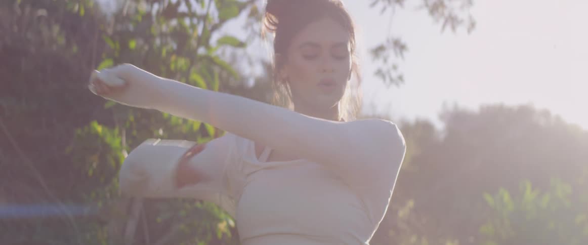 A woman breathes and stretches in the sunrise