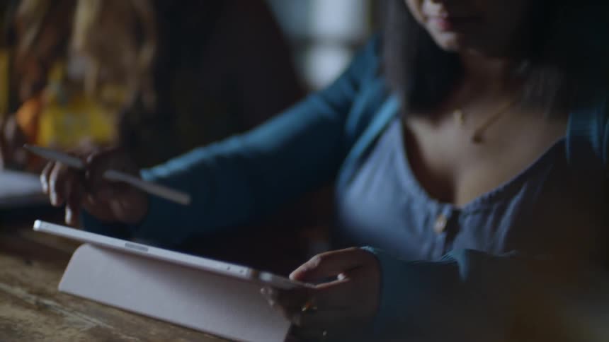 A woman swipes her finger along a tablet