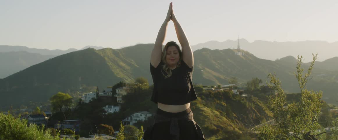 Woman doing yoga outdoors on a bright day