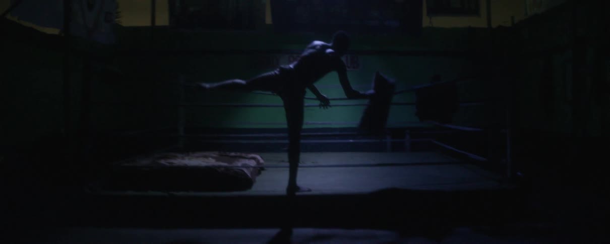 Man laying down on a bed in a boxing ring