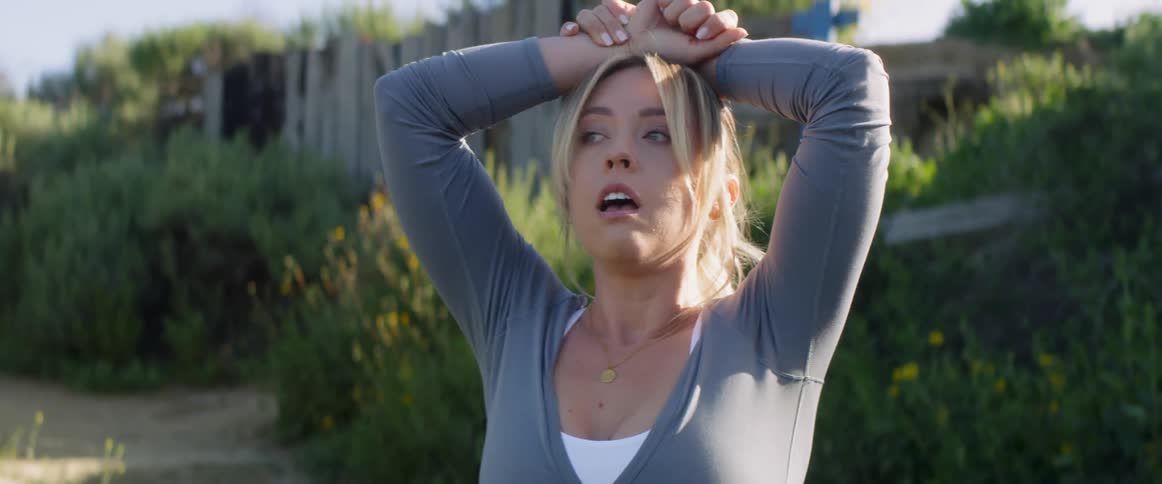 Woman breathes heavily with her hands on her head