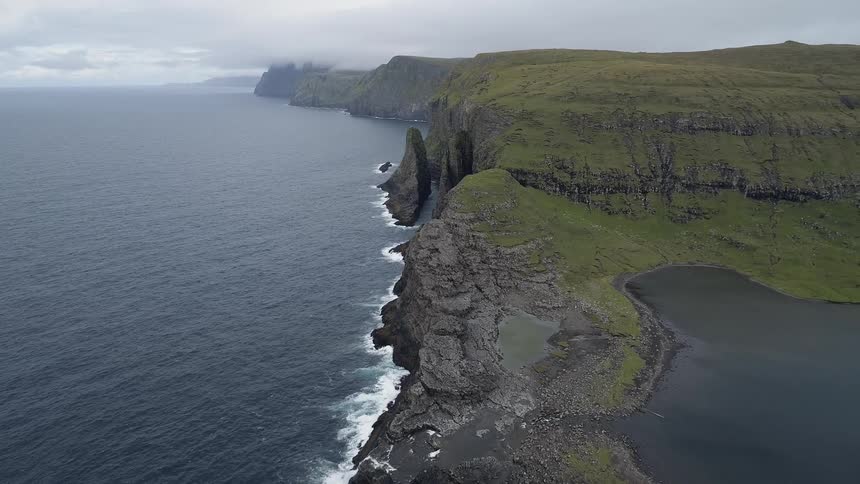 The waves flow towards the rocky shore