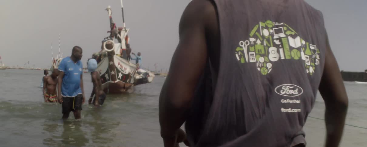 Man turns his head quickly and walks toward a boat