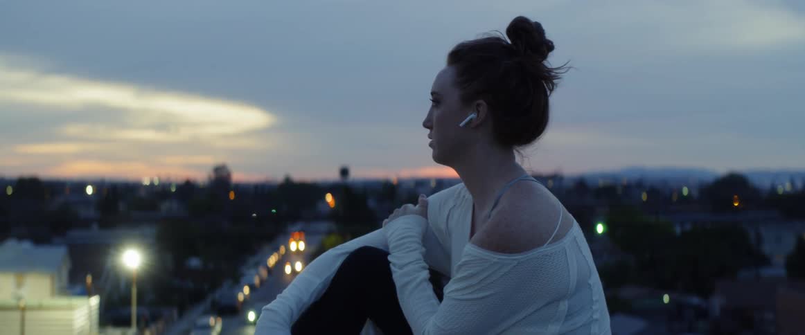 A woman uses her phone on the building rooftop