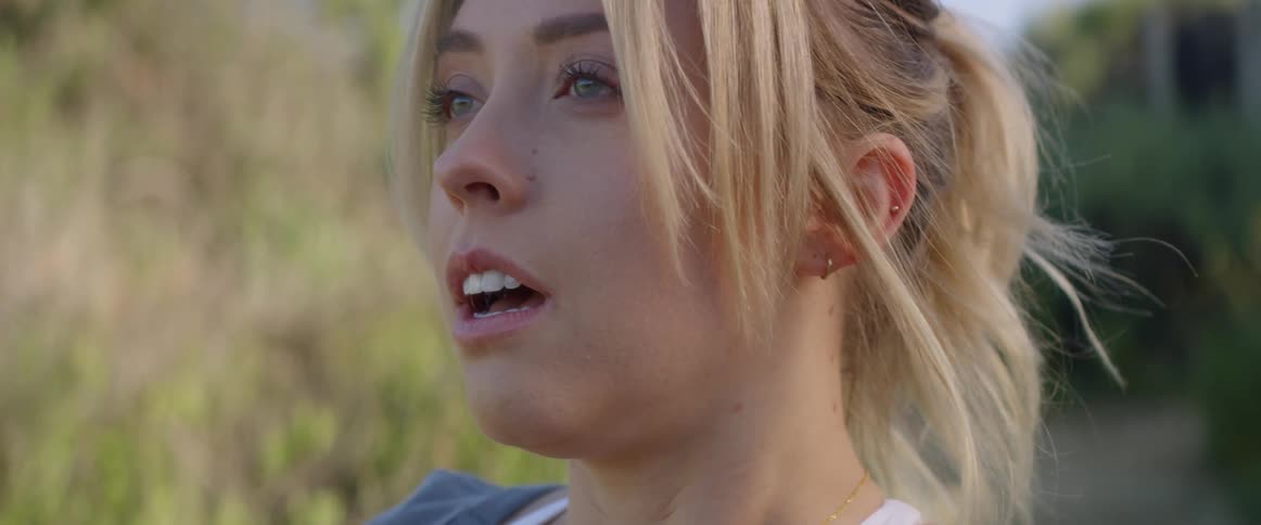 A woman stares blankly into the distance before walking