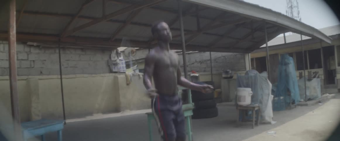 A man is jumping rope outside of a pavilion